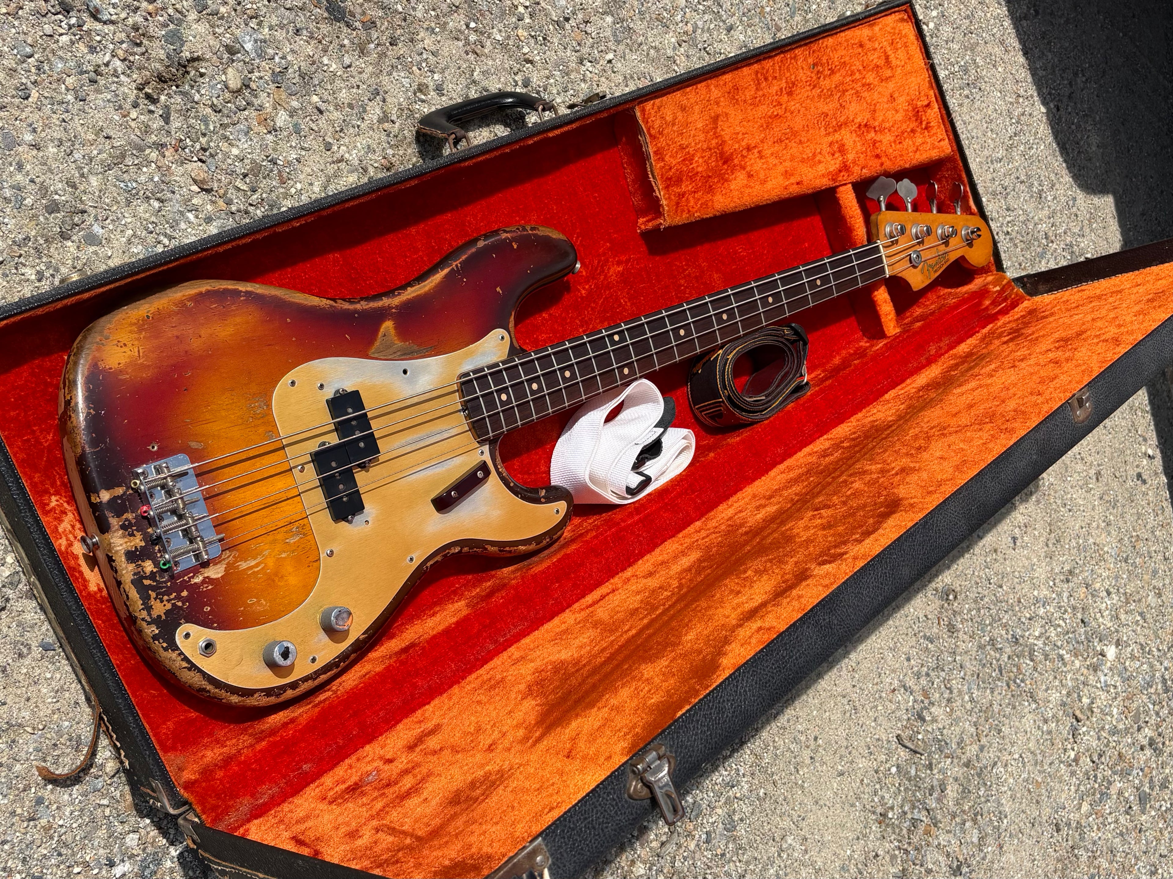 Vintage Fender bass guitar from the 1950s in a case on a concrete surface