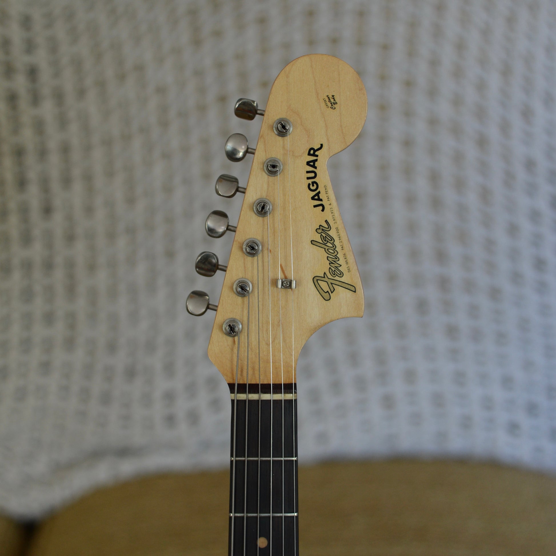 Fender Jaguar guitar headstock on a textured background
