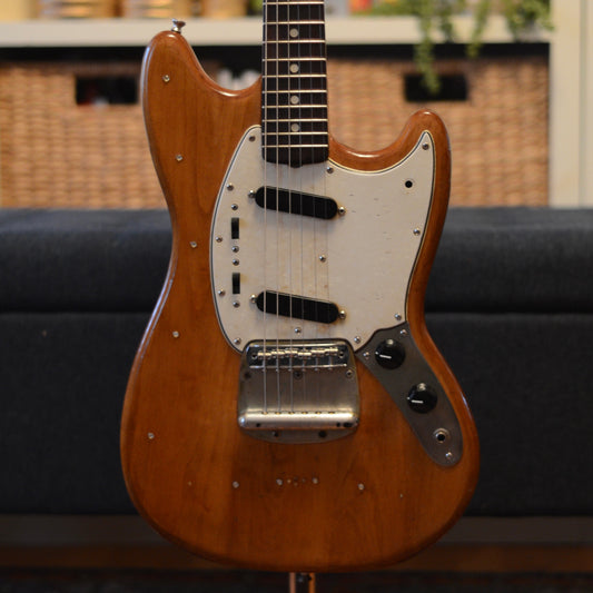 1965 Fender Mustang with a pearloid pickguard on a blurred background