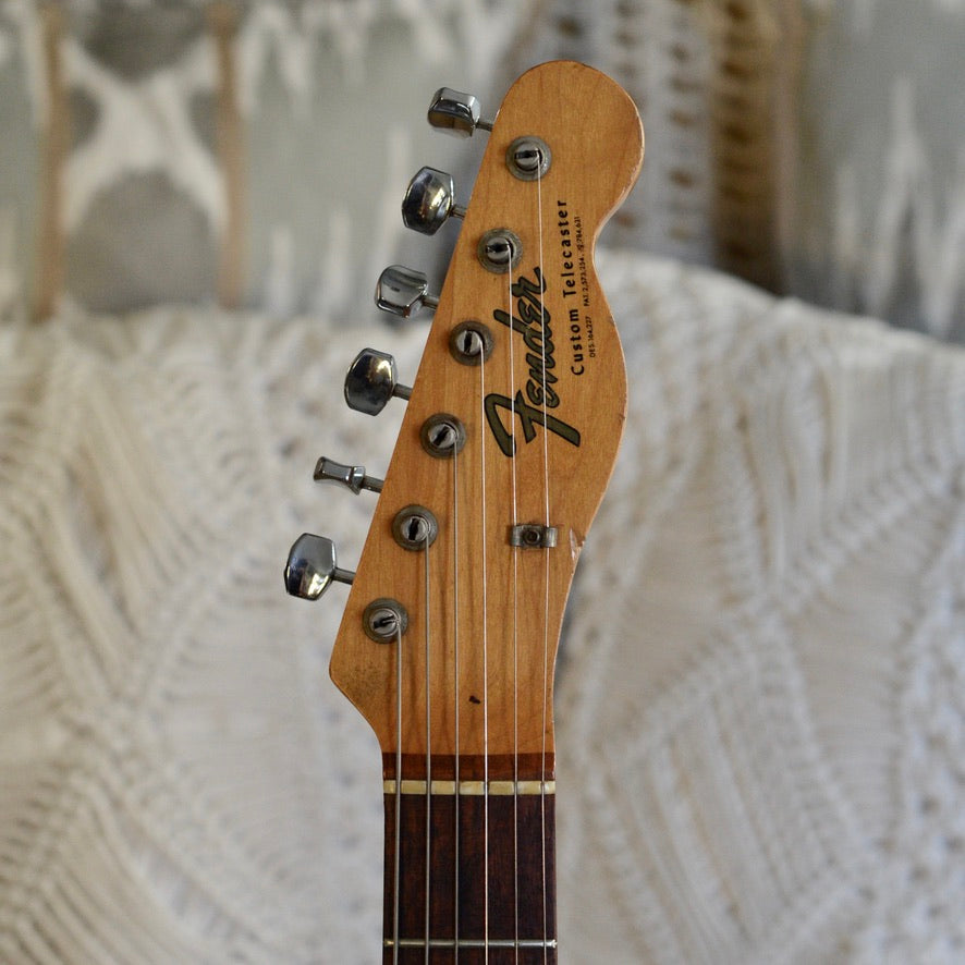 Fender guitar headstock on a textured surface